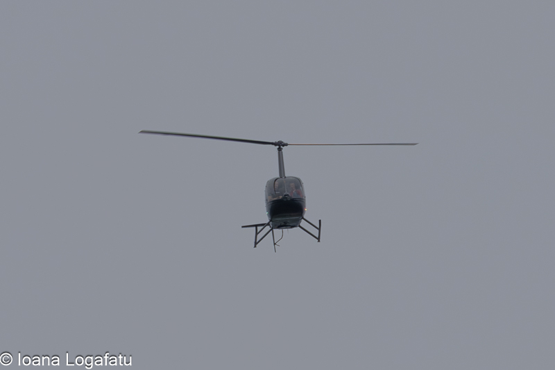 Helicopter flying through a cloudy sky over city